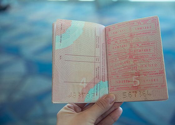 Hộ chiếu mở trong tay — hồ sơ bị trả về vì bảo hiểm sai